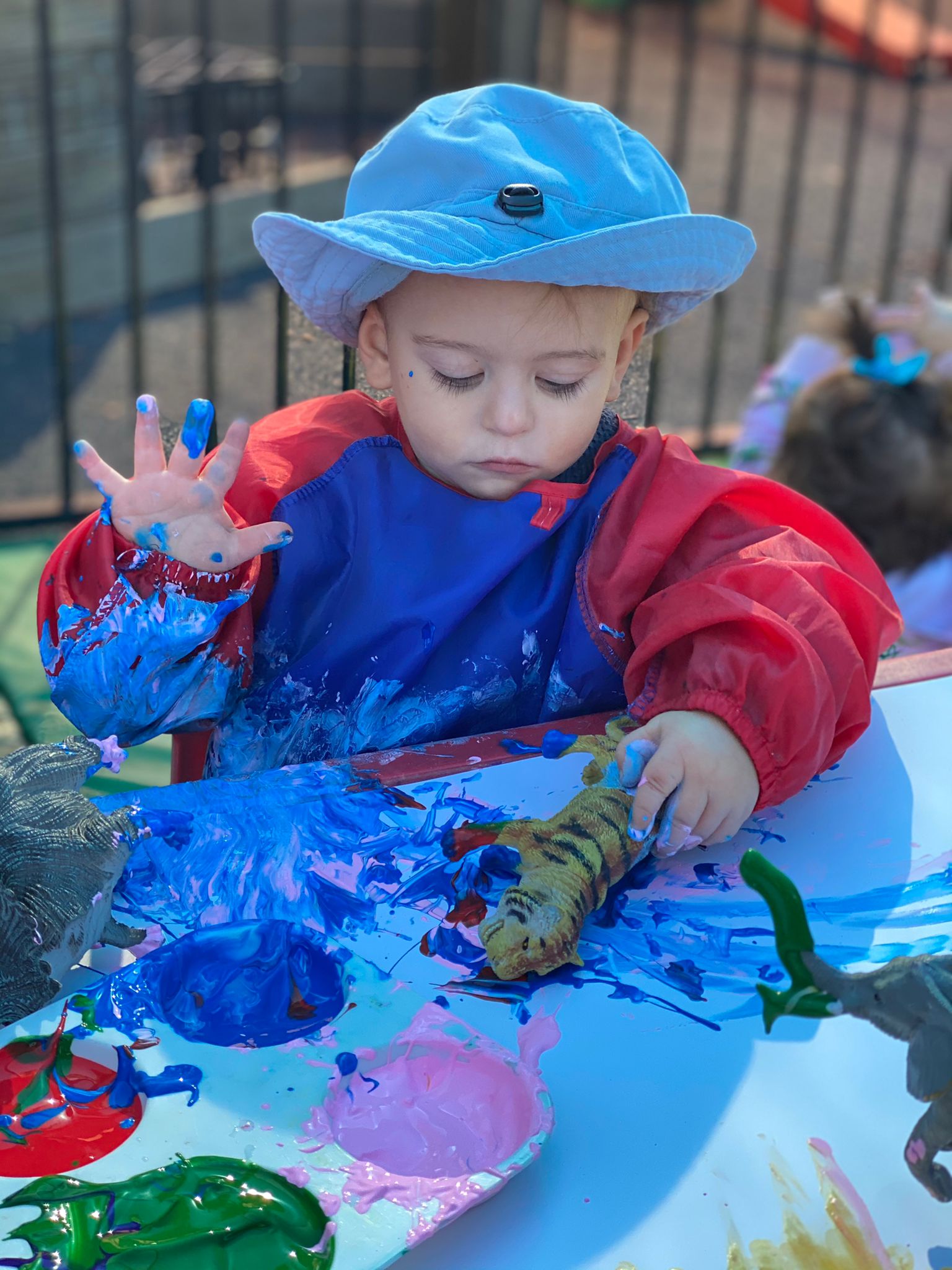 Child outdoors enjoying painting